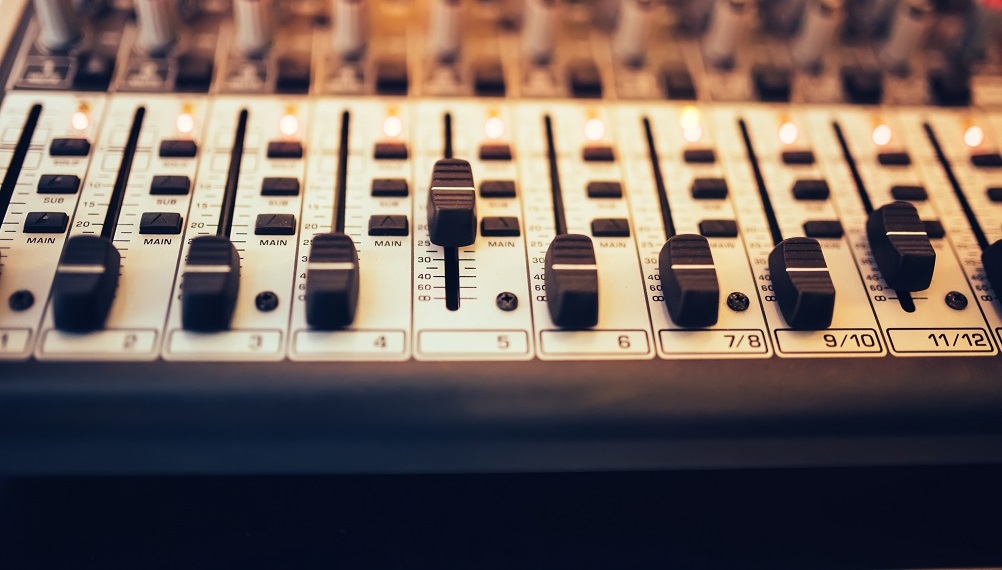 Detail of a music mixer in studio, dj working for new tracks. Music production with editing tools